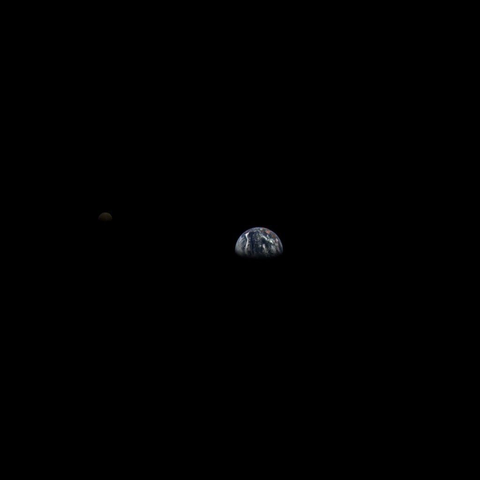 Photograph of the Earth (center) and the Moon (left), both lit from above and seen half full.