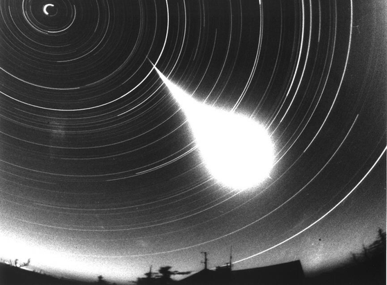 February 19, 1999

On The Trail Of A Fireball
 * Credit: Courtesy P. Spurny, (Astronomical Institute, Ondrejov Observatory)

Explanation: 
This exceptionally bright fireball meteor trail was photographed with a fish-eye camera at a Czech Republic station of the European Fireball Network on January 21, 1999. Of the star trails visible in this night-long exposure, the bright short arc in the upper left is due to Polaris, the north star. The breaks seen near the beginning of the fireball trail itself were produced by a shutter rotating 15 times a second. In all, three stations recorded the dazzling streak and their combined tracking information has revealed details of the meteor's brief atmospheric flight and previous interplanetary voyage. For example, the luminous trail is measured to begin at an altitude of 81.9 kilometers and covered 71.1 kilometers in 6.7 seconds. The projected prior orbit for the meteoroid corresponds to one typical for Apollo class asteroids which can cross Earth's orbit. In forty years of operations the European Network has multistation recordings of less than 10 or so fireballs as bright as this one. It is thought likely that a small (a few hundred grams) meteorite survived this fiery fall to Earth and landed near the Czech-Poland border. 

Authors & editors: Robert Nemiroff (MTU) & Jerry Bonnell (USRA)
NASA Technical Rep.: Jay Norris. Specific rights apply.
A service of: LHEA at NASA/ GSFC
& Michigan Tech. U.